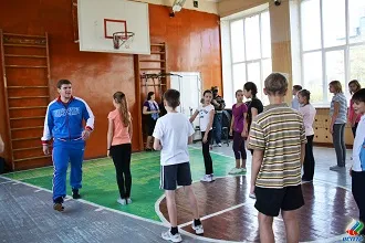 Школьники средних классов на уроке физкультуры