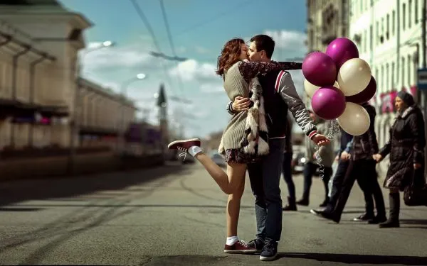 Влюблённая пара с воздушными шарами на городской улице