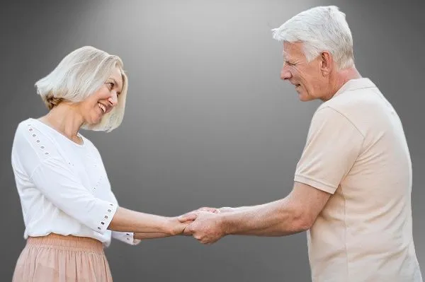 пожилая пара держат друг друга за руки